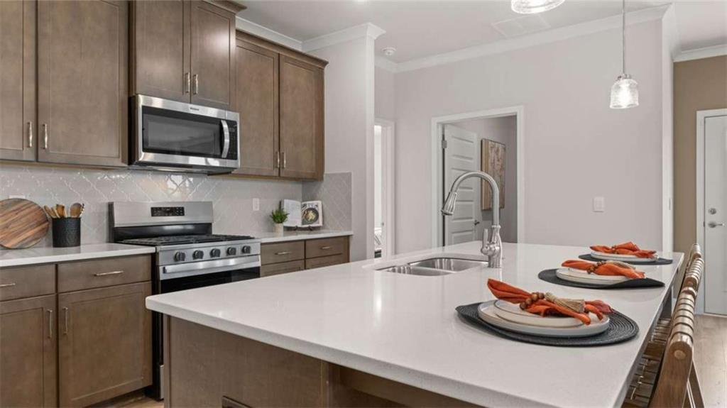 636 Parnassus Road Locust Grove, GA 30248 - Photo 16 of 44 a kitchen with a sink a stove and chairs