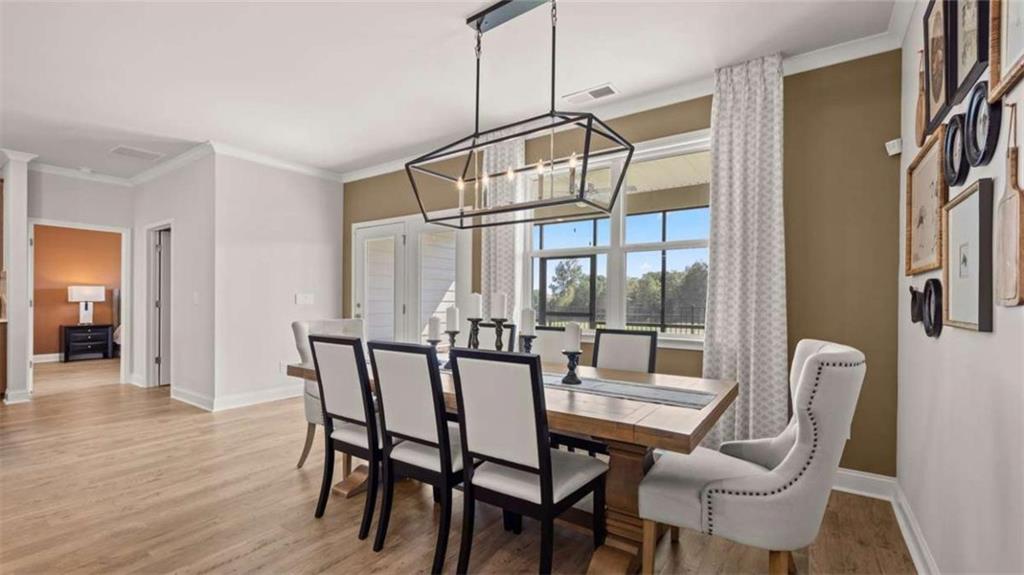636 Parnassus Road Locust Grove, GA 30248 - Photo 31 of 44 a dining room with furniture a chandelier and wooden floor