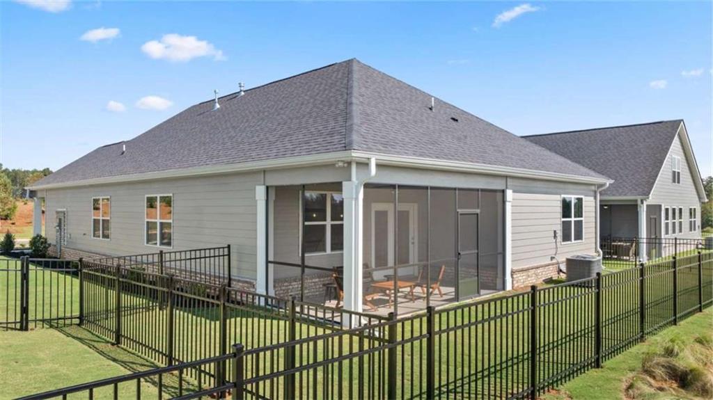 636 Parnassus Road Locust Grove, GA 30248 - Photo 42 of 44 a view of a house with large windows and a table and chairs