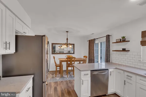 a kitchen with stainless steel appliances a dining table chairs and a refrigerator