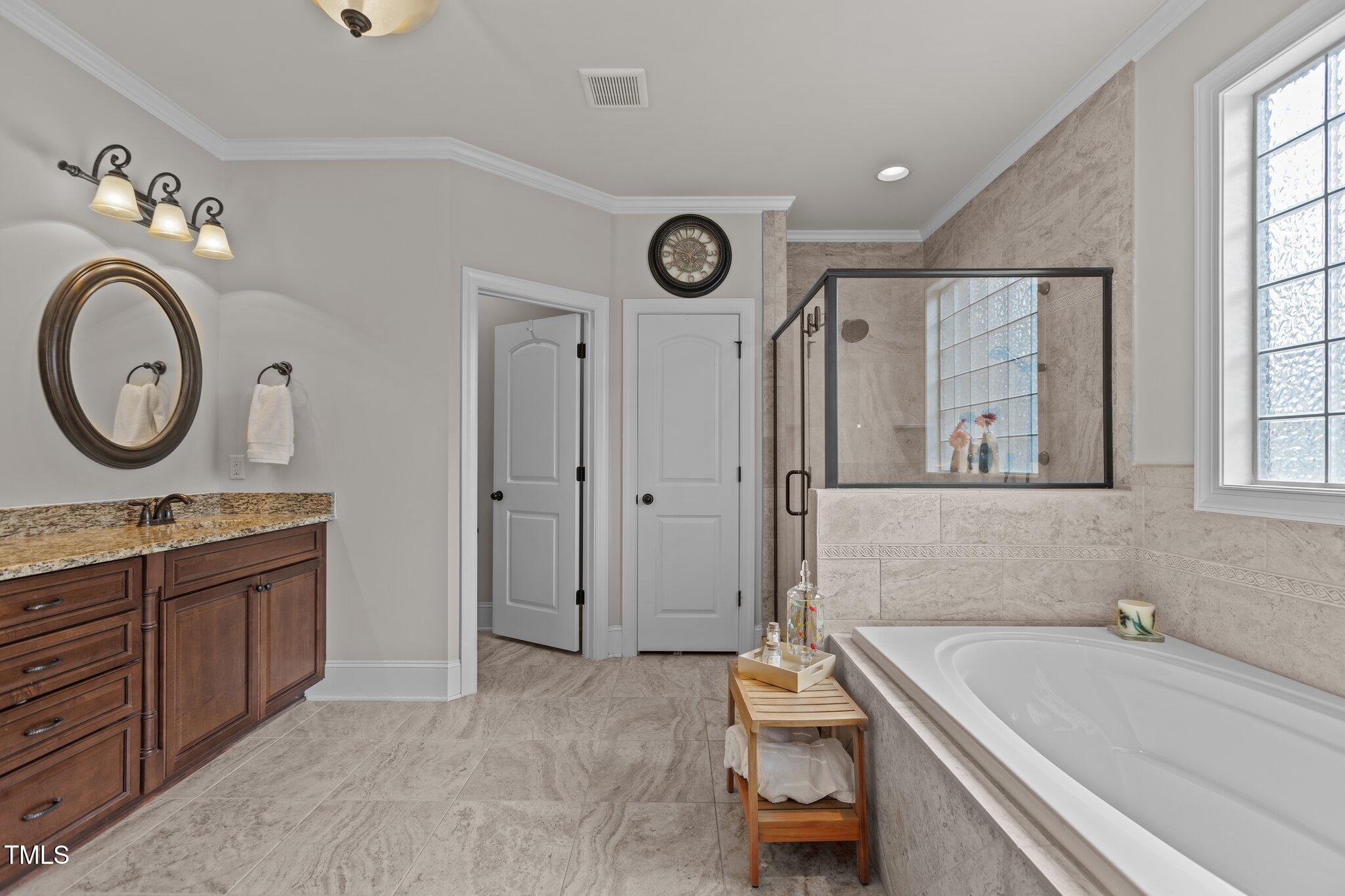 1512 Piazzo Court Apex, NC 27502 - Photo 20 of 59 a bathroom with a granite countertop sink and a bathtub