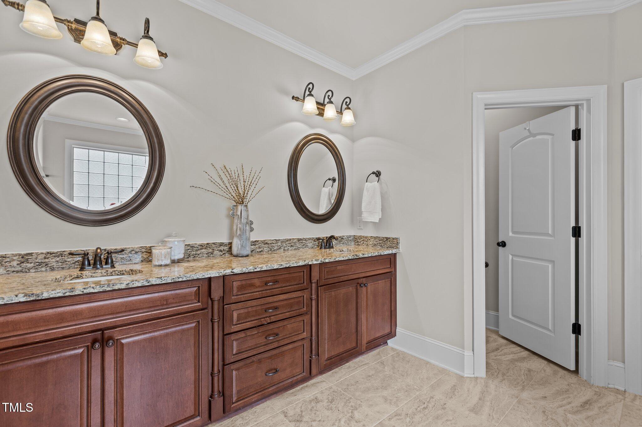1512 Piazzo Court Apex, NC 27502 - Photo 21 of 59 a bathroom with a granite countertop double vanity sink and a mirror