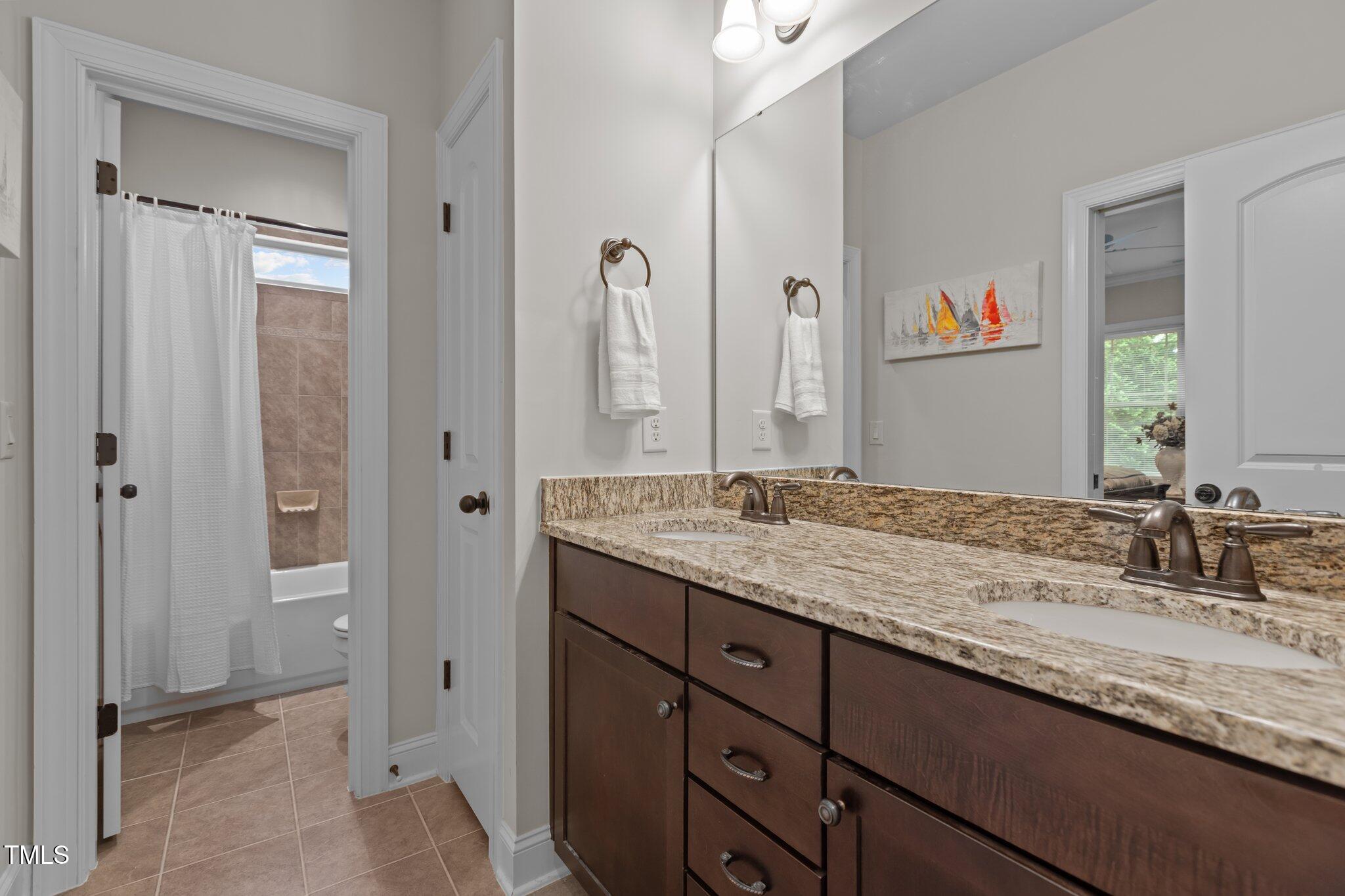 1512 Piazzo Court Apex, NC 27502 - Photo 30 of 59 a bathroom with a granite countertop double vanity sink and a mirror