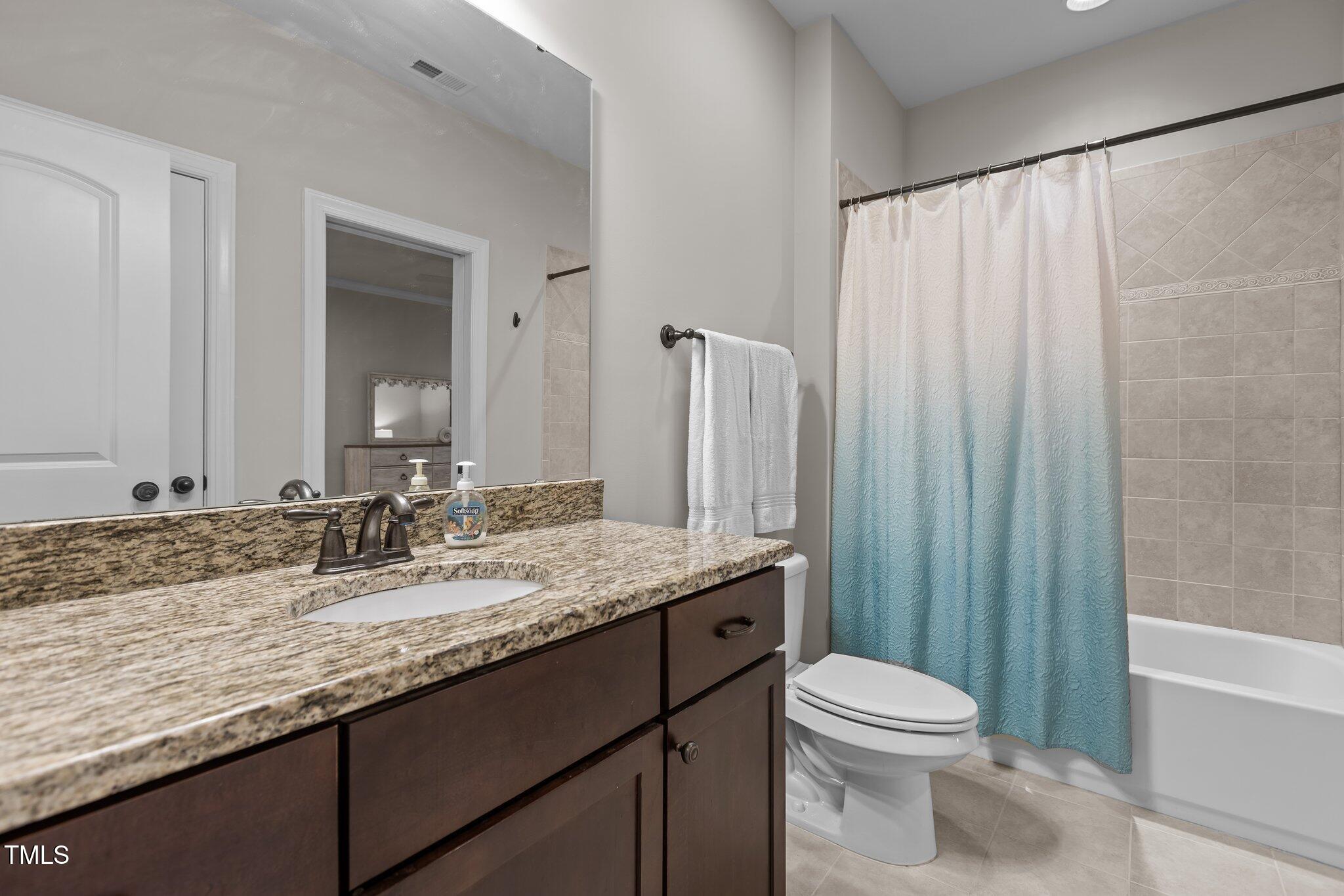 1512 Piazzo Court Apex, NC 27502 - Photo 34 of 59 a bathroom with a granite countertop sink toilet and shower