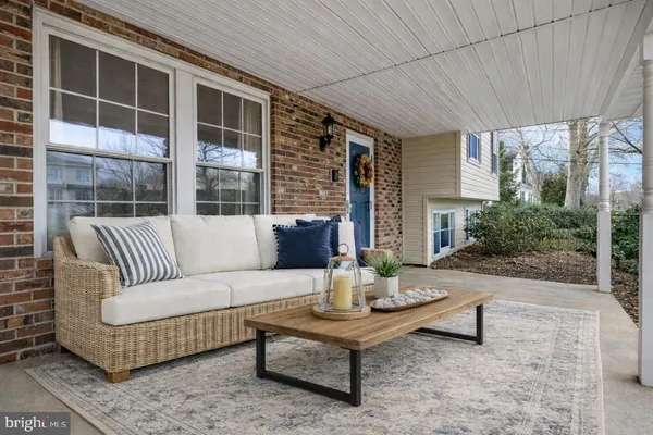 a view of a patio with couches chairs and wooden floor