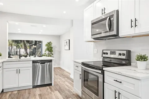 a kitchen with stainless steel appliances granite countertop a stove a sink and a microwave
