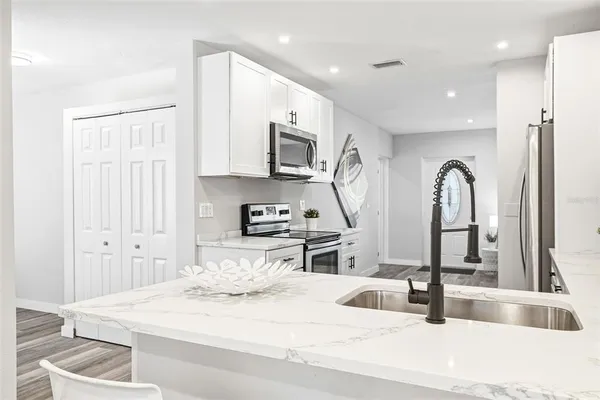 a large white kitchen with stainless steel appliances