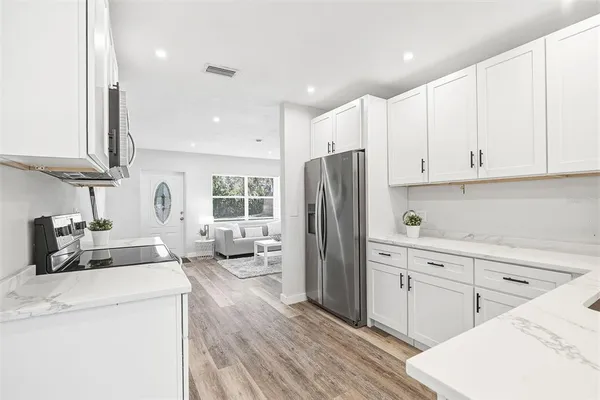 a kitchen with stainless steel appliances a refrigerator sink and cabinets