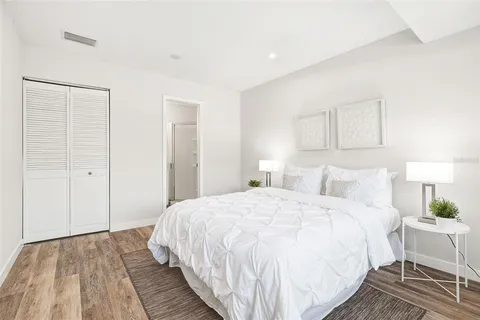 a bedroom with a bed and a lamp on dresser