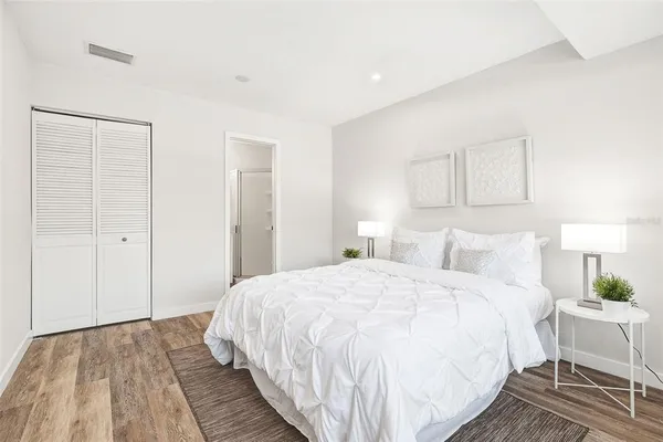 a bedroom with a bed and a lamp on dresser