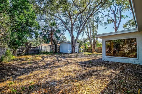 a view of a backyard with large trees