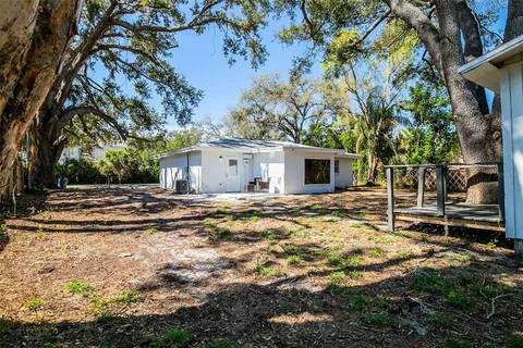 a view of a house with a yard and large tree