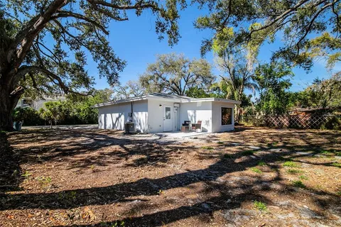 a view of a house with a yard and tree