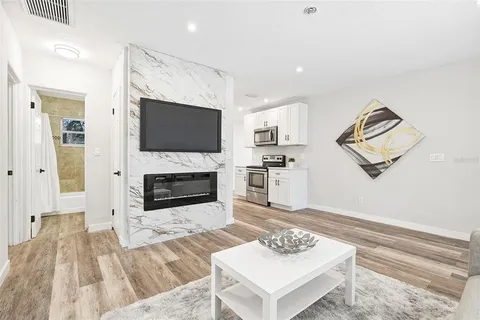 a living room with furniture a flat screen tv and a fireplace