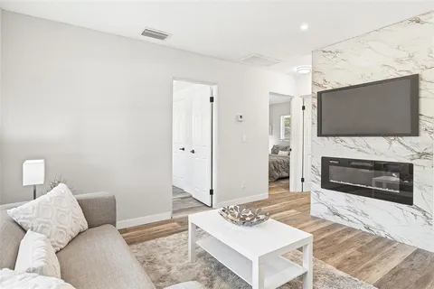 a living room with furniture a fireplace and a flat screen tv