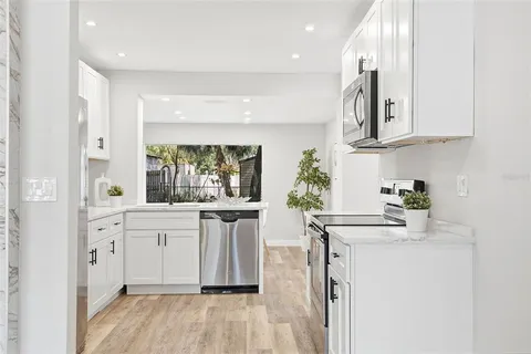 a kitchen with stainless steel appliances granite countertop a sink and cabinets