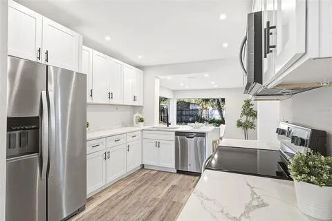 a kitchen with a sink stainless steel appliances and cabinets