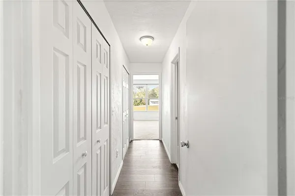 a view of a hallway with wooden floor and entryway