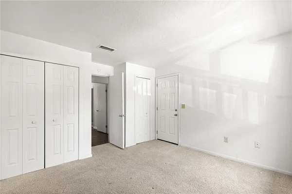 an empty room with windows and closet