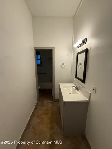a bathroom with a sink a toilet and mirror
