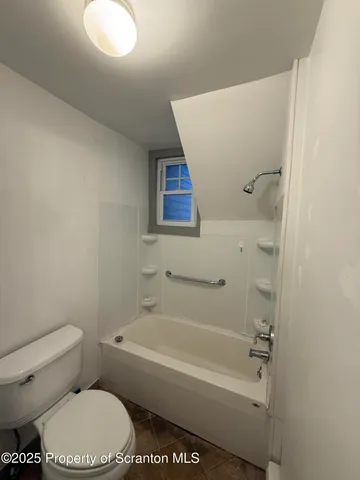 a bathroom with a toilet and a bathtub