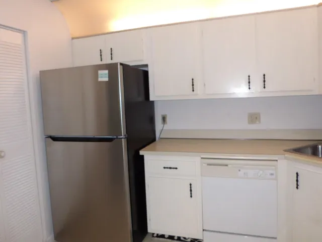 a white refrigerator freezer sitting inside of a kitchen