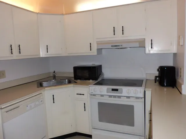 a kitchen with a stove and white cabinets