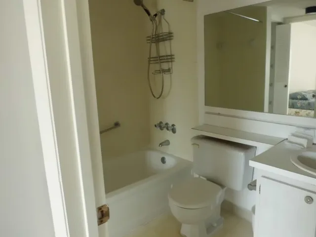 a bathroom with a granite countertop toilet a sink and bathtub