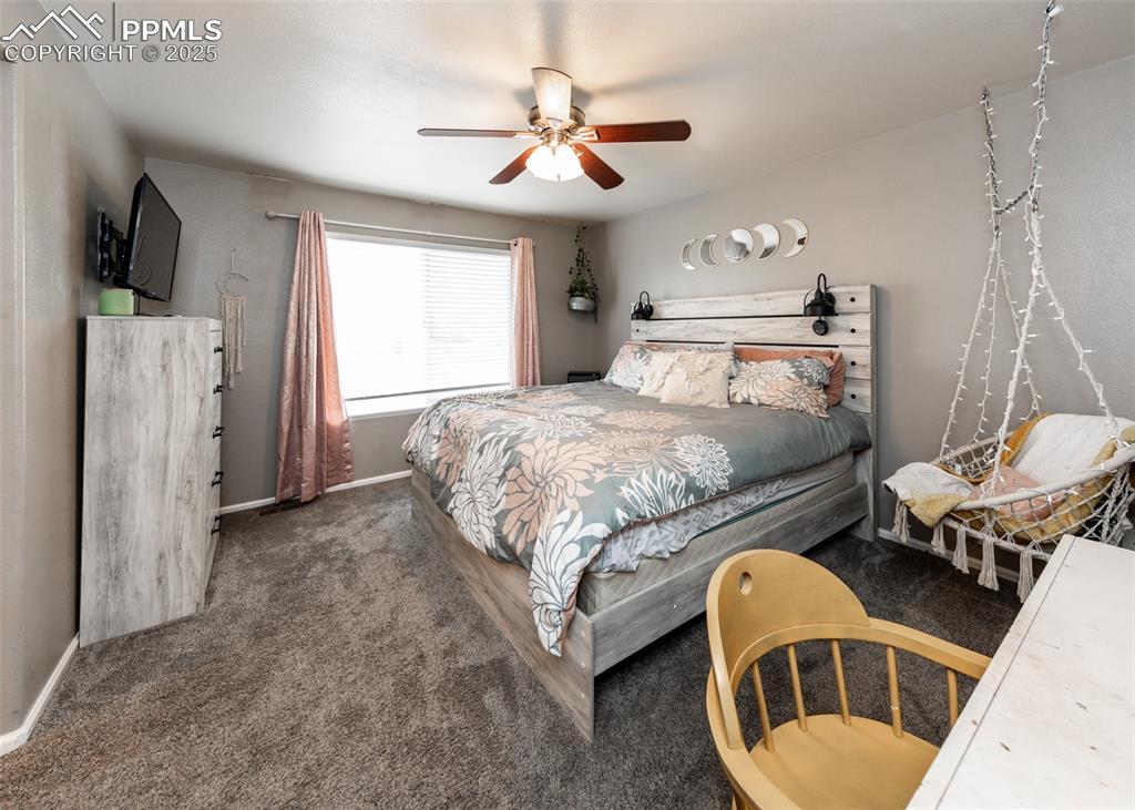 7751 Tompkins Road Peyton, CO 80831 - Photo 14 of 26 a bedroom with a bed couch and a window