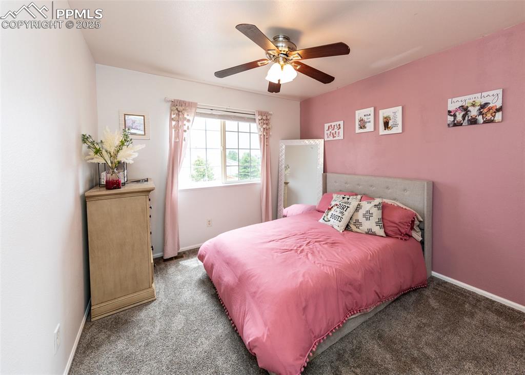 7751 Tompkins Road Peyton, CO 80831 - Photo 15 of 26 a bedroom with a bed and a chandelier