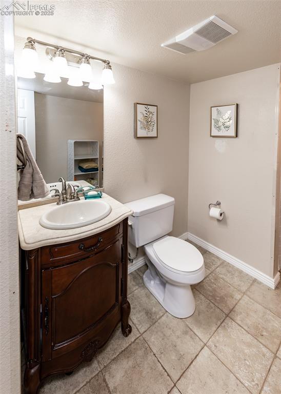 7751 Tompkins Road Peyton, CO 80831 - Photo 7 of 26 a bathroom with a toilet a sink and mirror