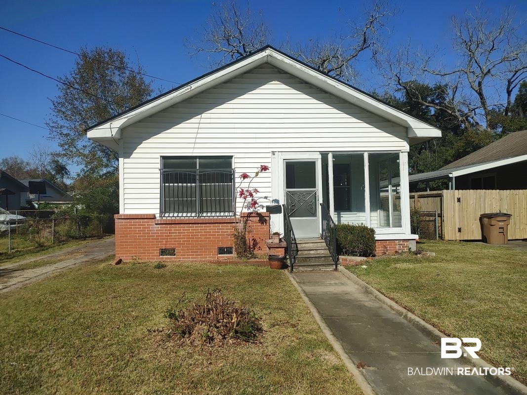 1706 Lomeroy Street Mobile, AL 36604 - Photo 1 of 24 Bungalow-style home featuring entry steps, crawl space, fence, a front yard, and brick siding