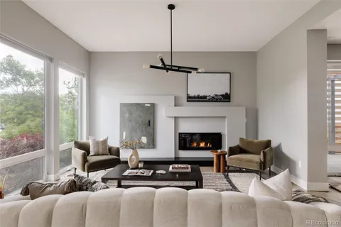 a living room with furniture a fireplace and a floor to ceiling window