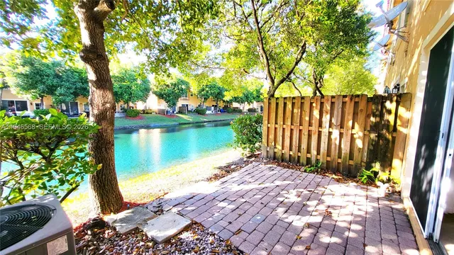 a view of a backyard with wooden fence and large trees