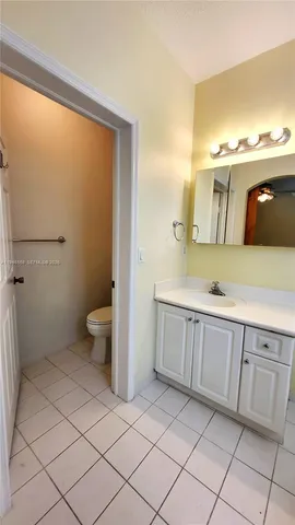 a spacious bathroom with a granite countertop sink a toilet and a mirror