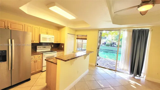 a kitchen with stainless steel appliances granite countertop a refrigerator and a stove