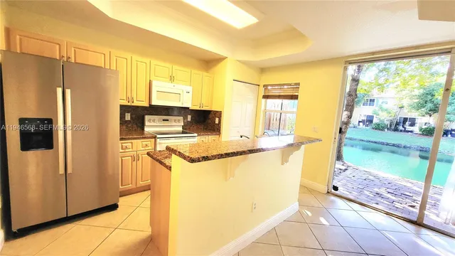 a kitchen with stainless steel appliances granite countertop a refrigerator a stove and a cabinets