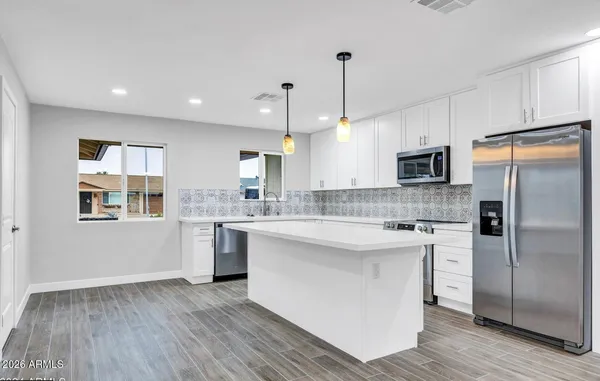 a kitchen with kitchen island white cabinets and stainless steel appliances