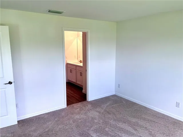 an empty room with windows and cabinet