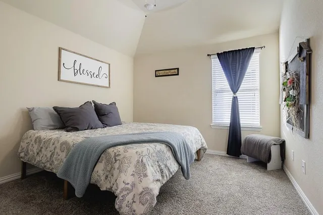 a spacious bedroom with a bed and a window