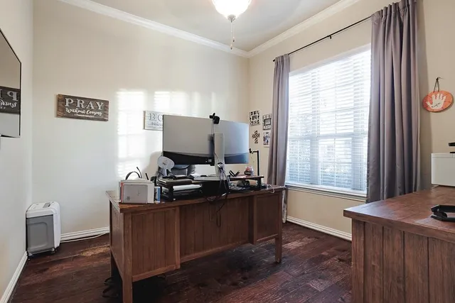 a view of a workspace with furniture and a window