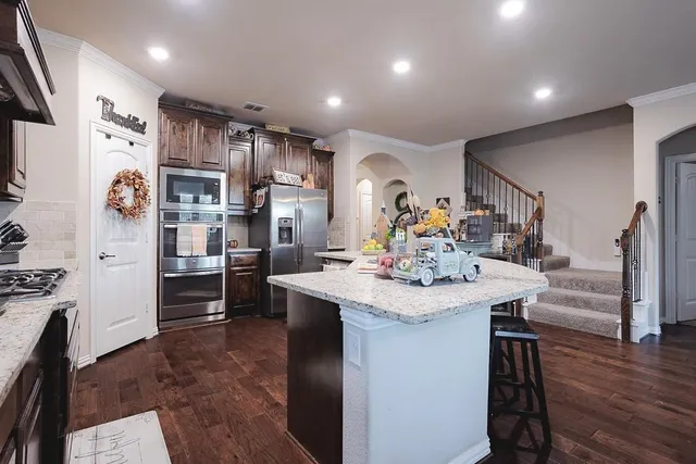 a kitchen with stainless steel appliances kitchen island a refrigerator sink and cabinets