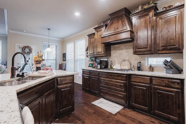 a kitchen with granite countertop a sink stainless steel appliances and cabinets