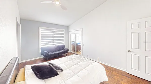 a bedroom with a bed and wooden floor
