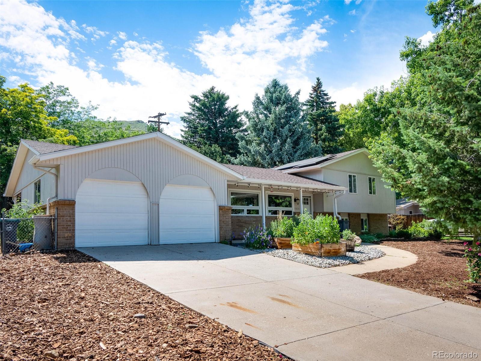 1826 Smith Road Golden, CO 80401 - Photo 1 of 35 a front view of a house with a garden and mountain view