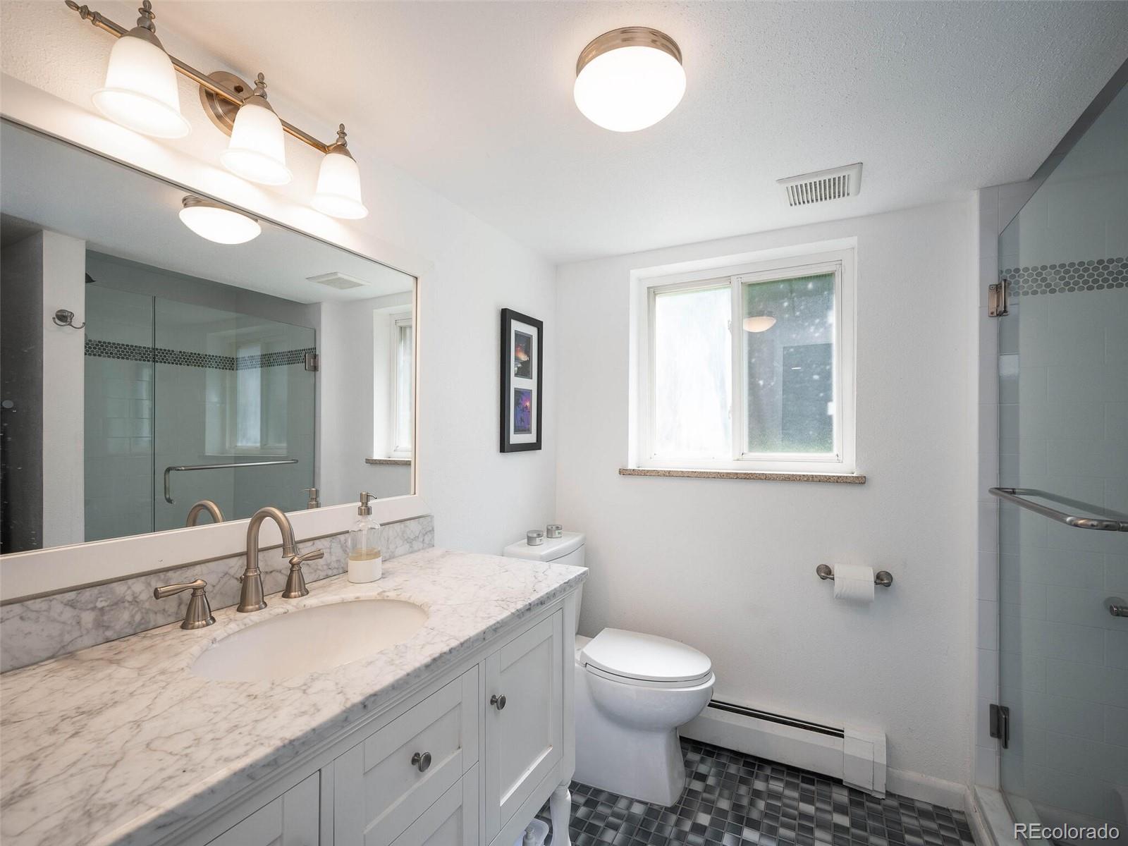1826 Smith Road Golden, CO 80401 - Photo 29 of 35 a bathroom with a granite countertop sink mirror vanity and toilet
