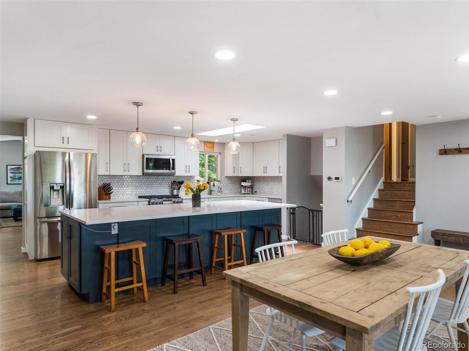1826 Smith Road Golden, CO 80401 - Photo 8 of 35 a kitchen with stainless steel appliances kitchen island granite countertop a table chairs and a refrigerator