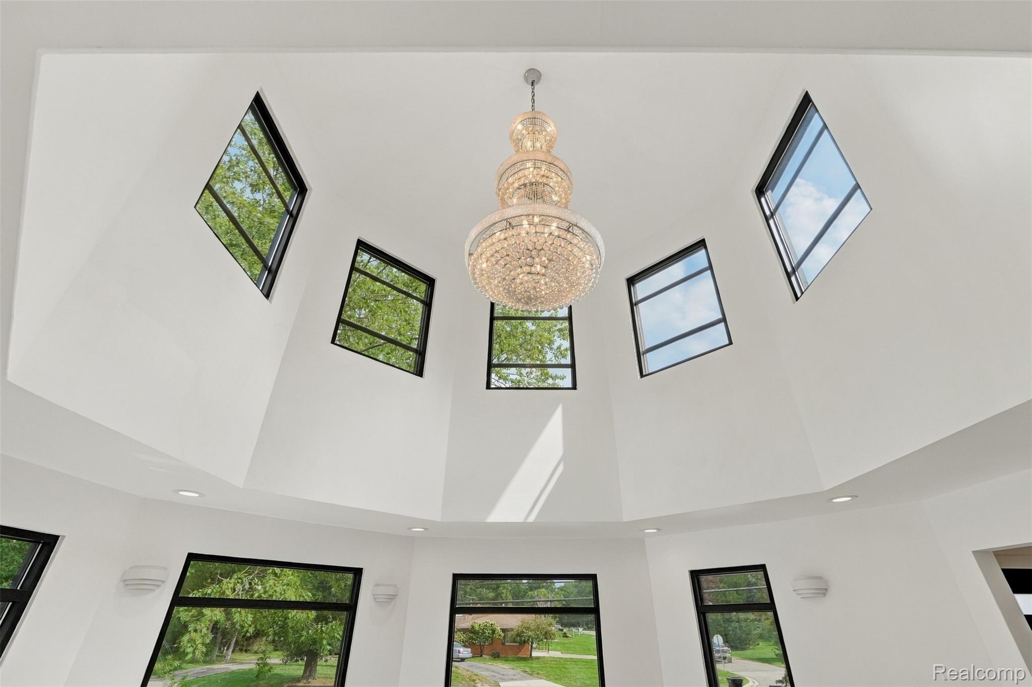 27507 Bell Road Southfield, MI 48034 - Photo 13 of 81 Vaulted ceiling with multiple angular windows, a large tiered chandelier, and recessed lighting
