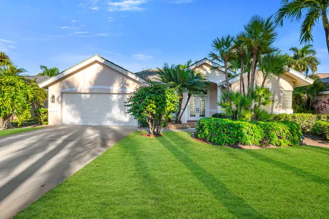 a front view of a house with a yard and potted plants
