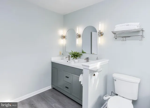 a kitchen with stainless steel appliances kitchen island granite countertop a refrigerator a stove top oven a sink dishwasher a dining table and chairs with wooden floor